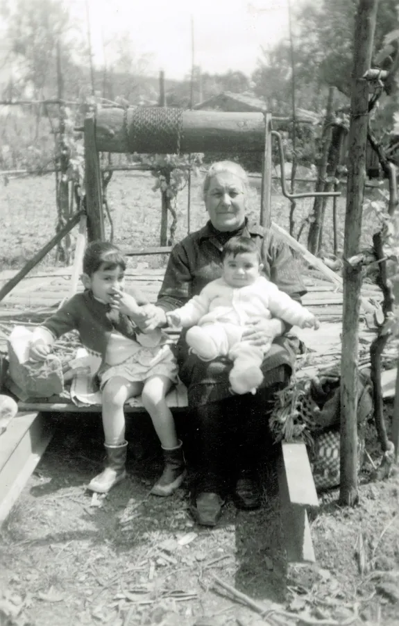 Imagem onde se vê pessoas sentadas num sarilho que existia na aldeia (s.d.). Espólio da família de José e Maria Helena Jorge.